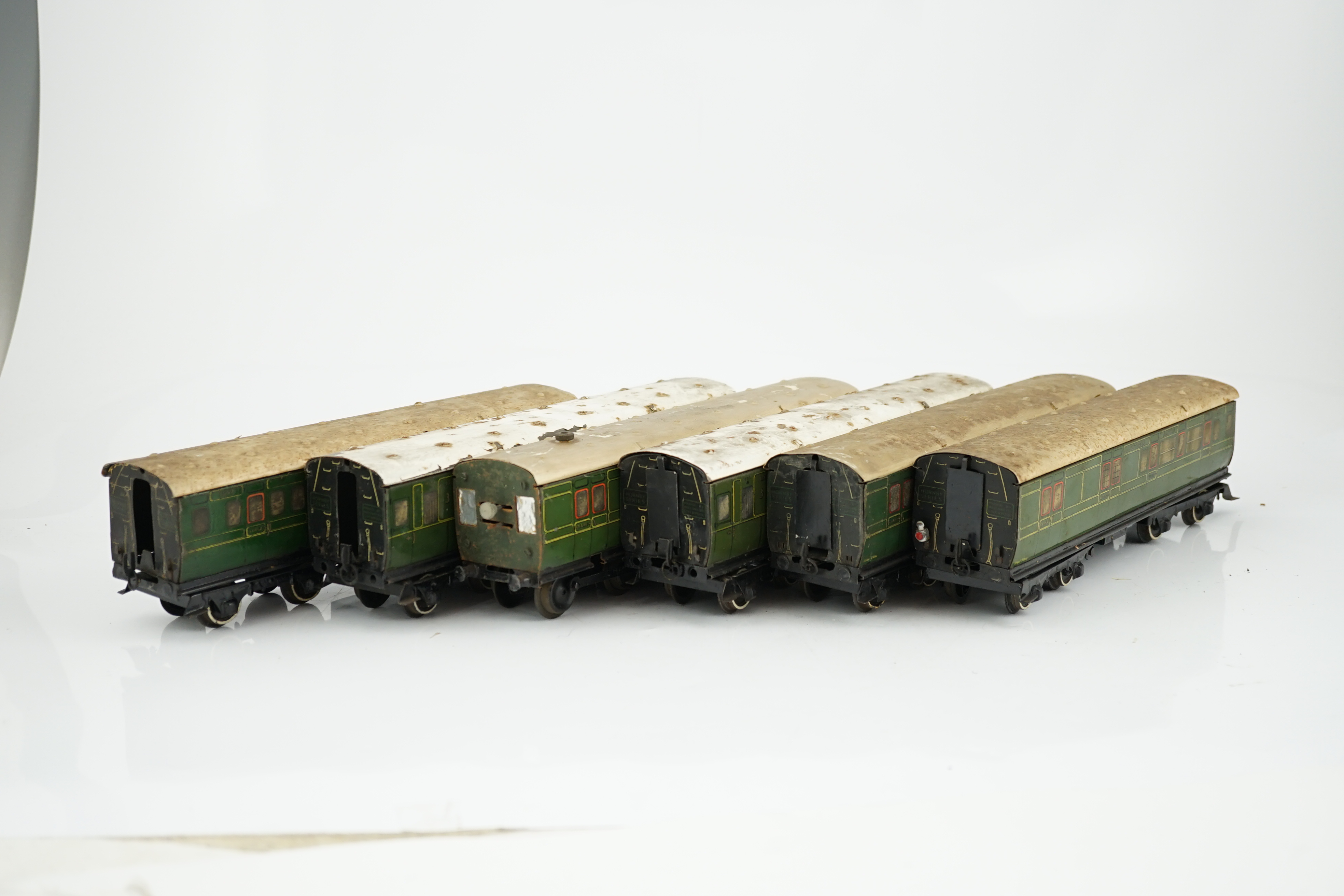 Six Hornby 0 gauge tinplate No.2 coaches in Southern Railway livery, one coach adapted to a driving unit with clockwork motor and replacement bogie